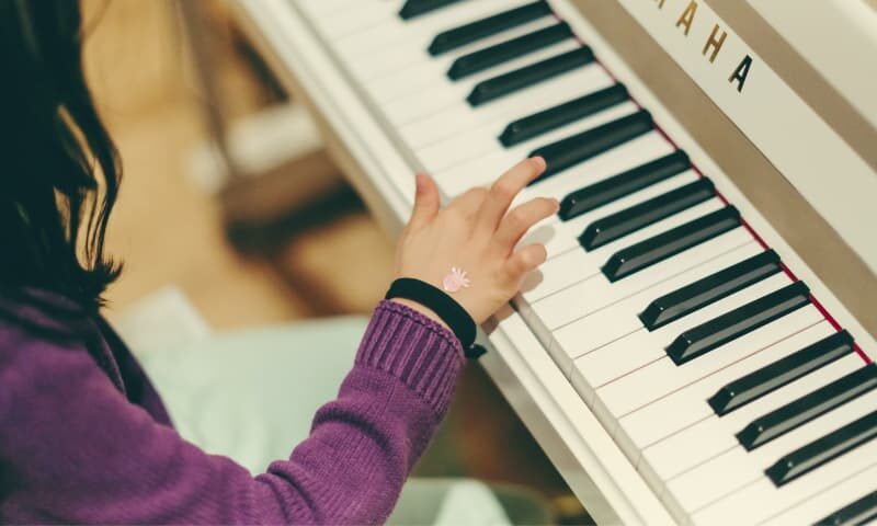 Kiedy jest ten odpowiedni czas, by zacząć naukę gry na instrumencie?, Dziecko grające na fortepianie, szkoła muzyczna